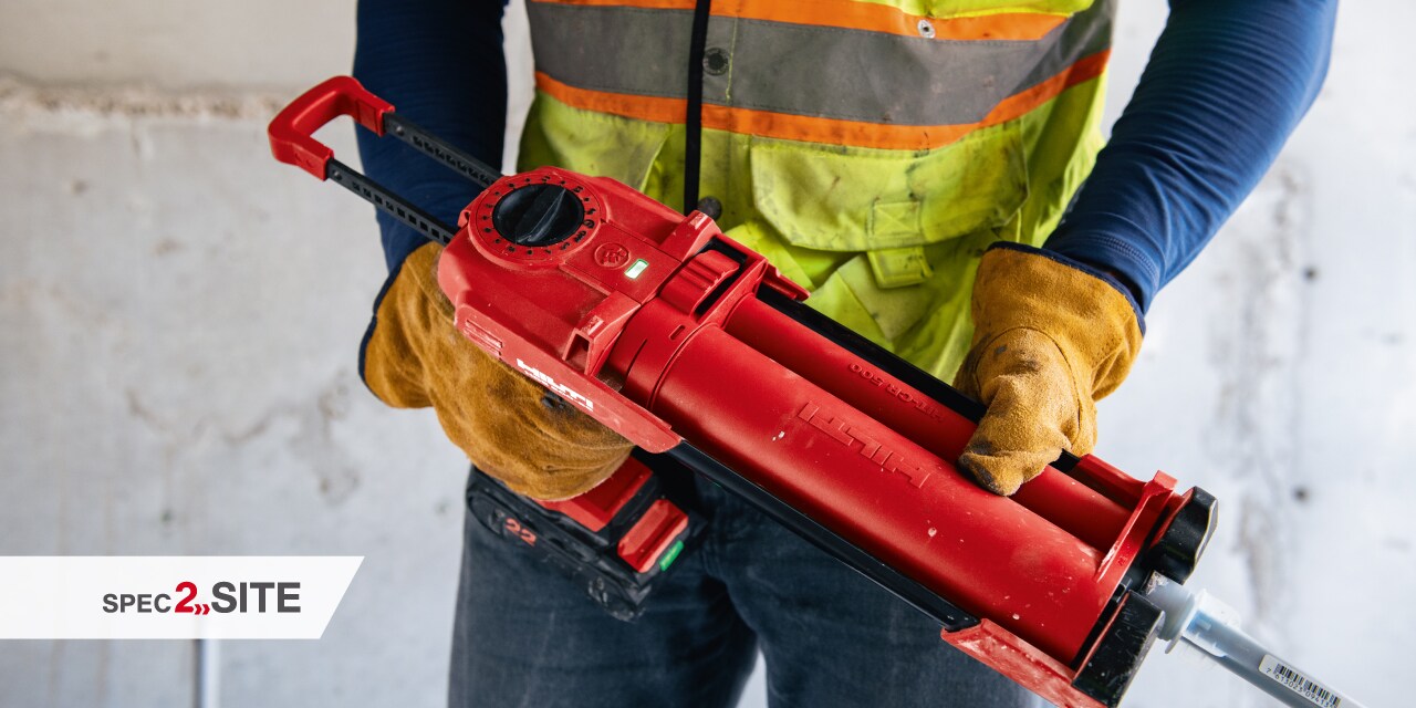 a worker uses a cordless driver to install a firestop device to a wall